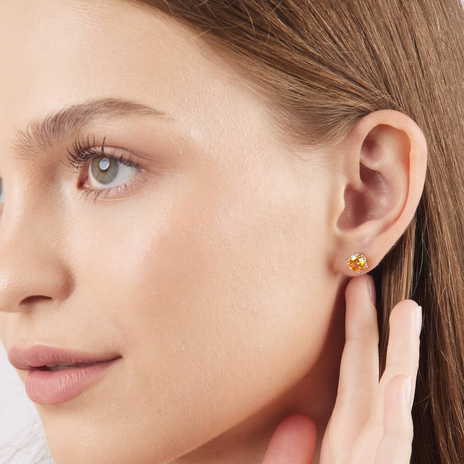 Model wearing the 1 carat moissanite stud earrings in yellow
