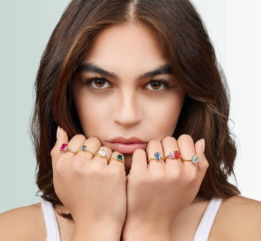 Model wearing a bunch of Alexander D gemstone rings