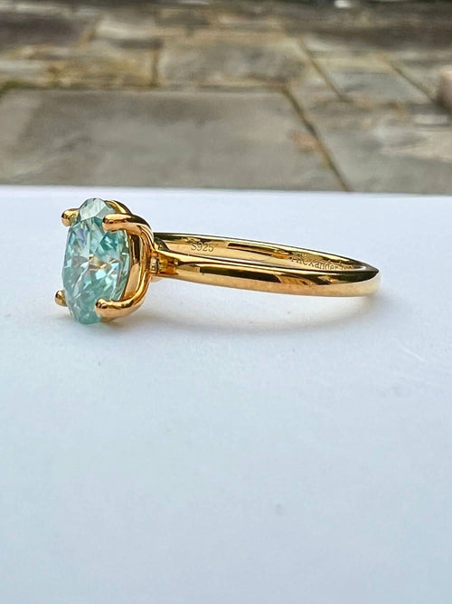 side view of blue green moissanite ring